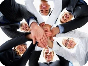 Sechs Personen im kreis mit Händen in der Mitte